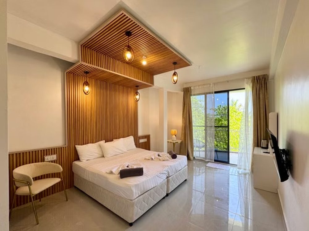 Double room with teak slat wall and balcony doors
